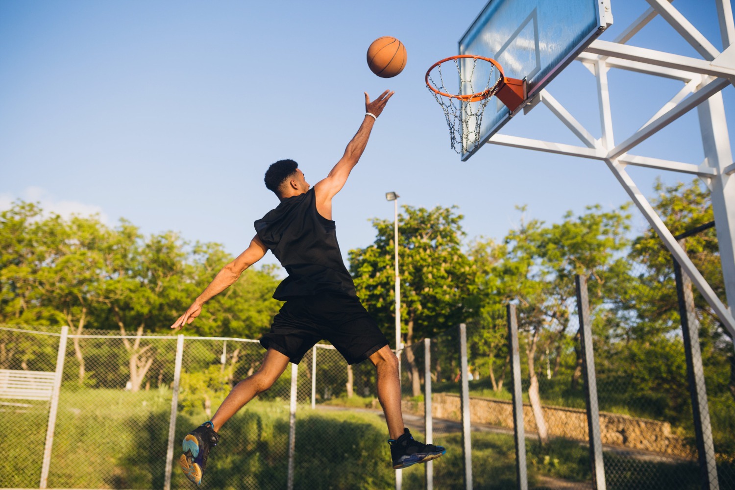 cool-black-man-doing-sports-playing-basketball-sunrise-jumping